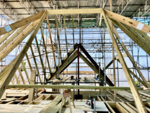 Timber roof structure under construction, showcasing modern building techniques for energy-efficient homes.